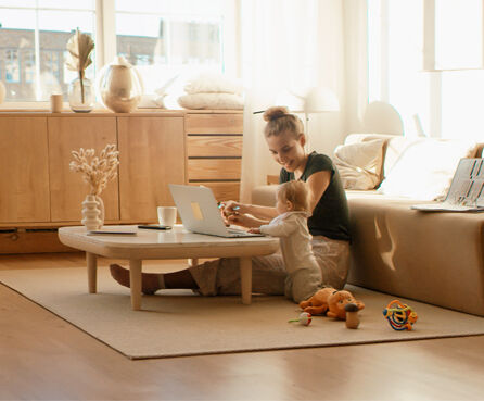 Caucasian mother working from home, having a work video call, daughter playing nearby