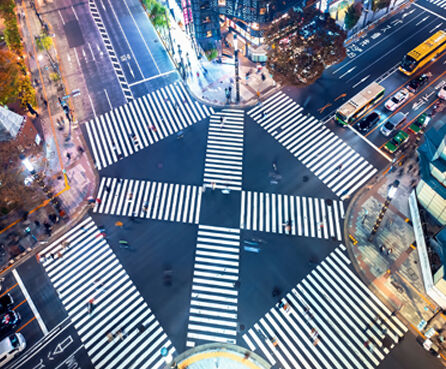 Traffic and people cross a busy intersection in Ginza, Tokyo
