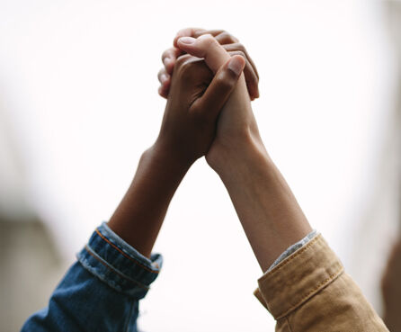 Closeup of two activists holding hands protesting