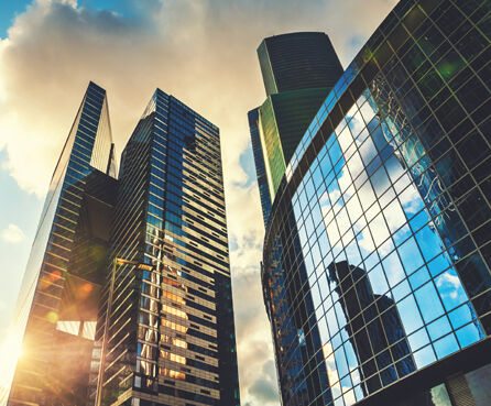 Modern glass skyscrapers against sky sunset bottom up view