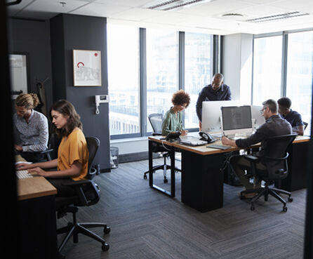 Young creative team working together on computers, casual office seen from doorway