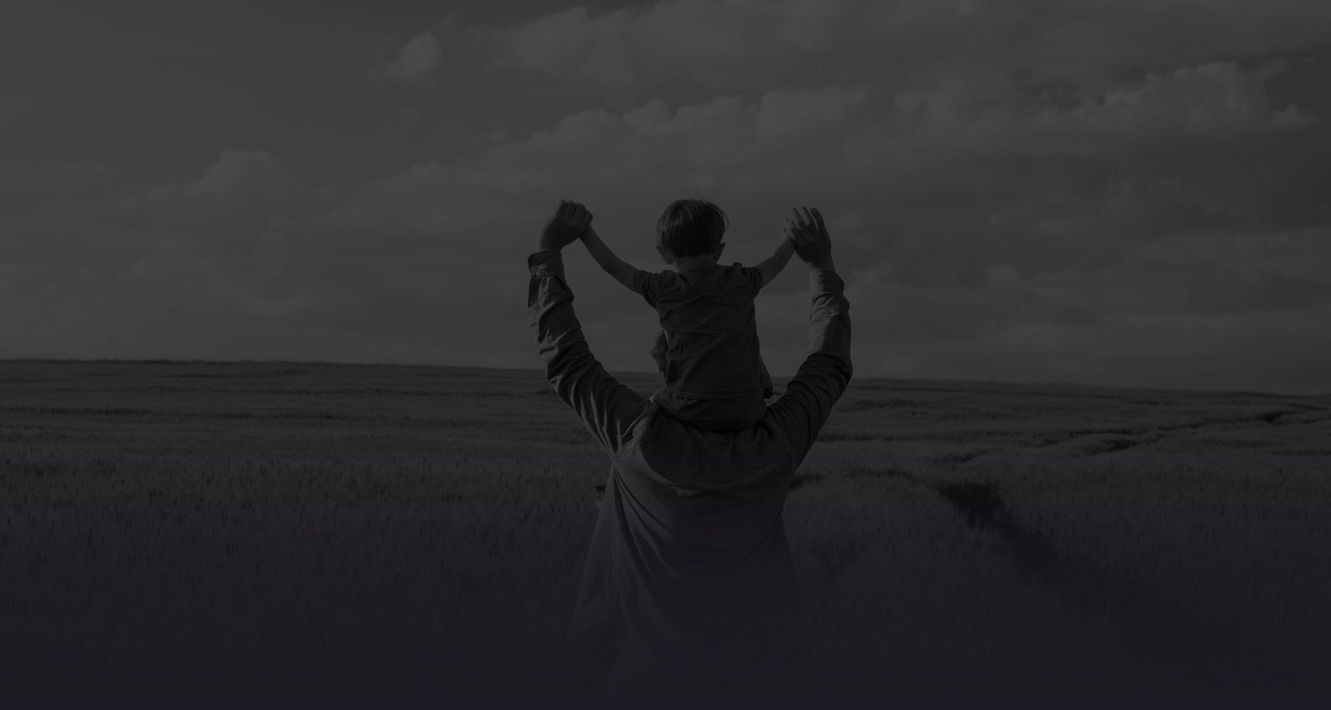 Father and son in wheat field, child sitting on his fathers shoulders