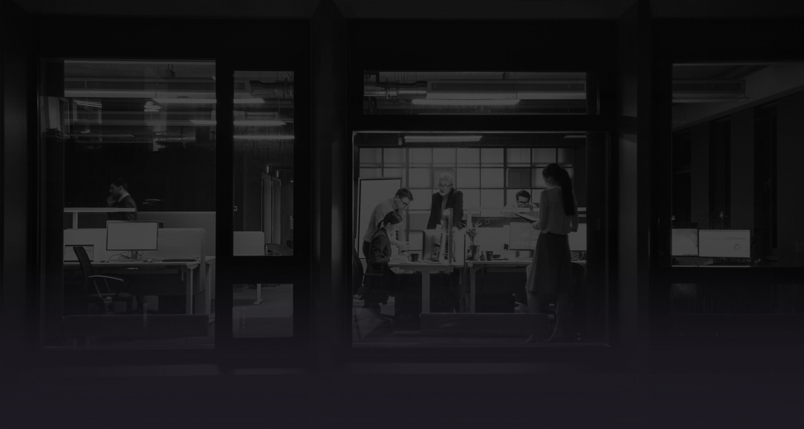 Shot from outside the window. Businessmen and businesswomen working in the office analyzing matters .
