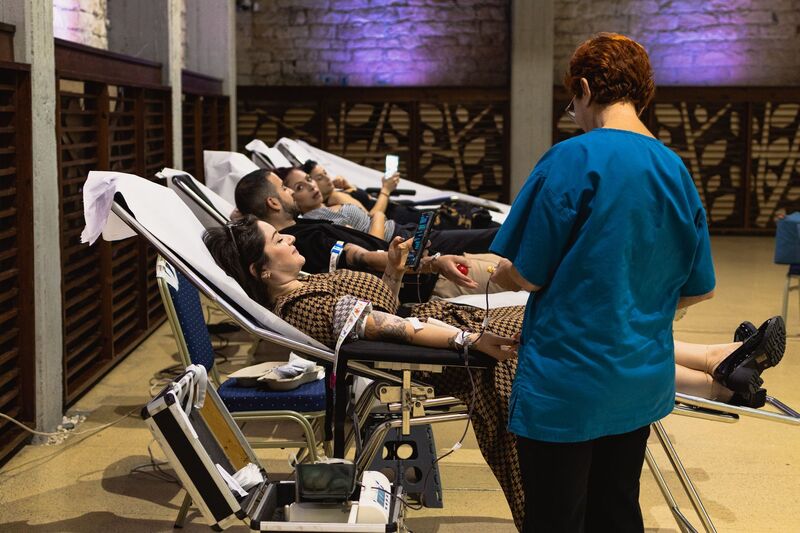 Blood donors laying on bed giving blood