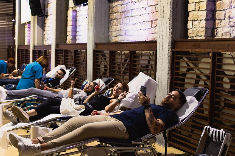 Blood donors laying on bed giving blood