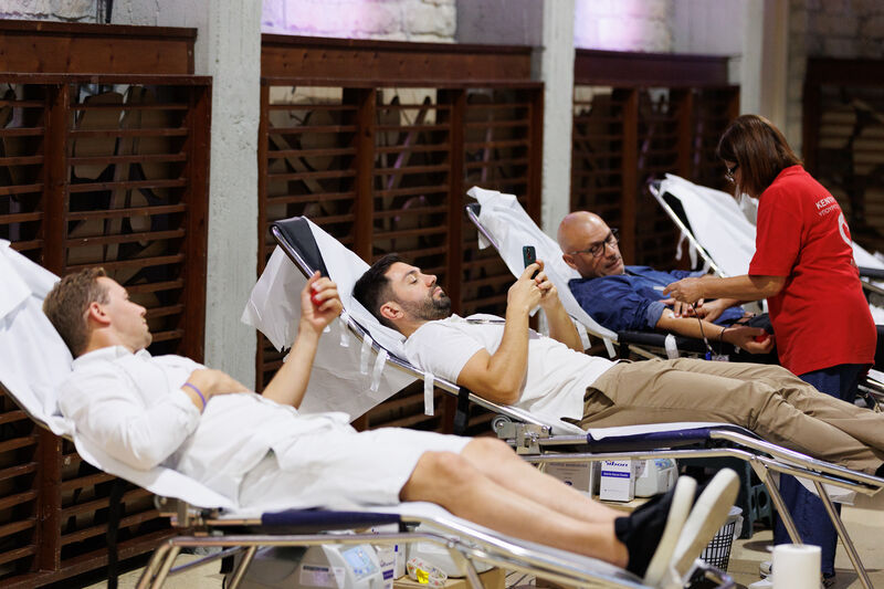 People lying in beds giving blood