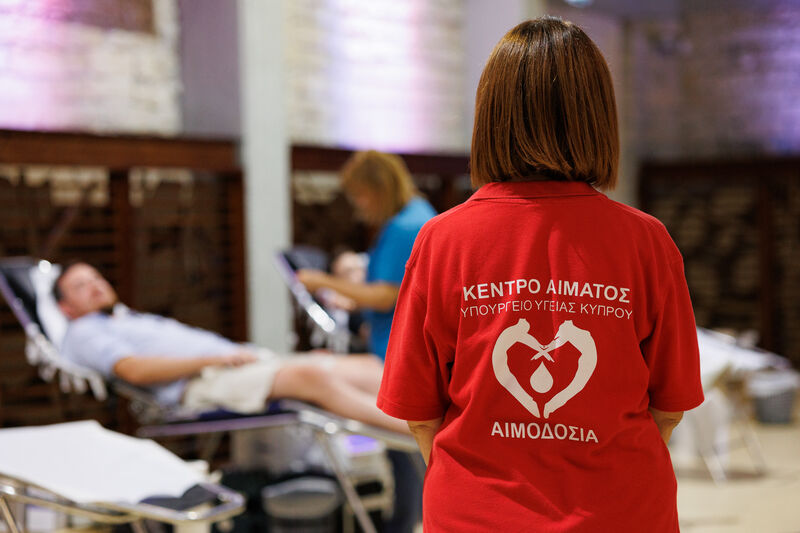 Back side of a nurse showing the logo of blood donation