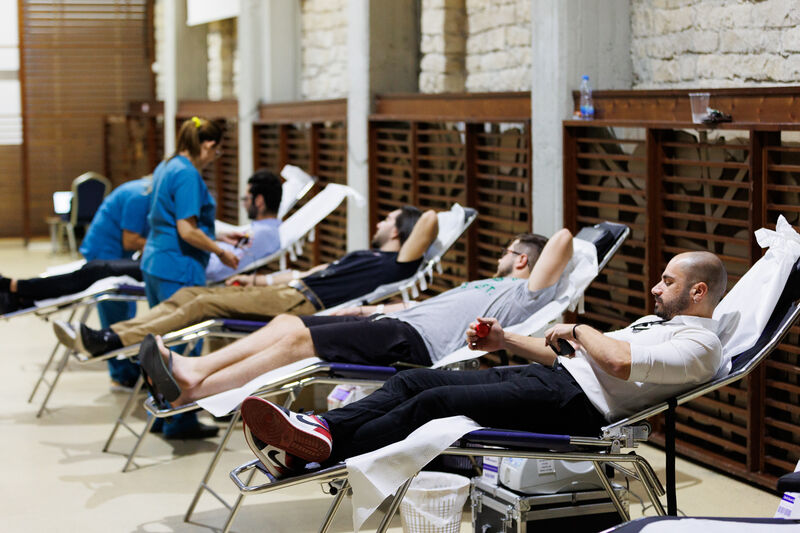 People lying in beds giving blood