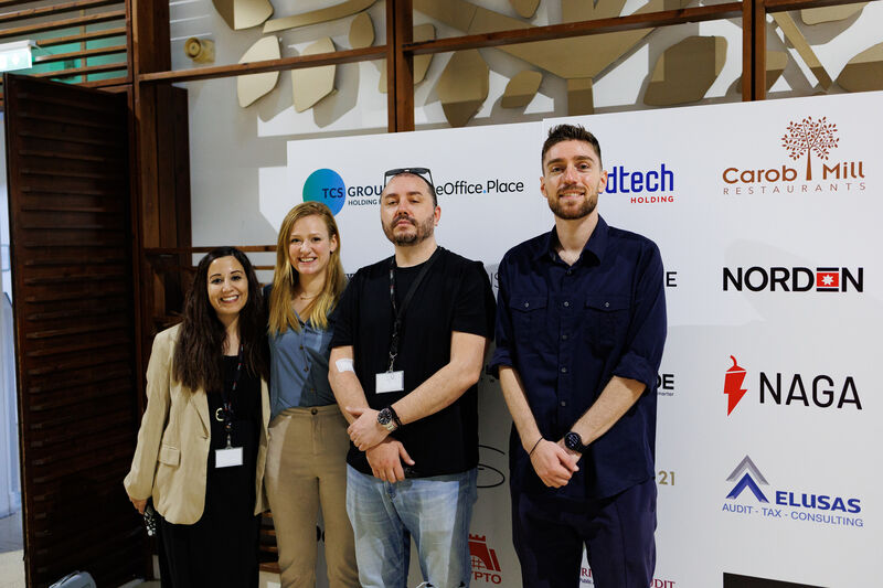 People standing in front of a photopanel wall for their picture taken